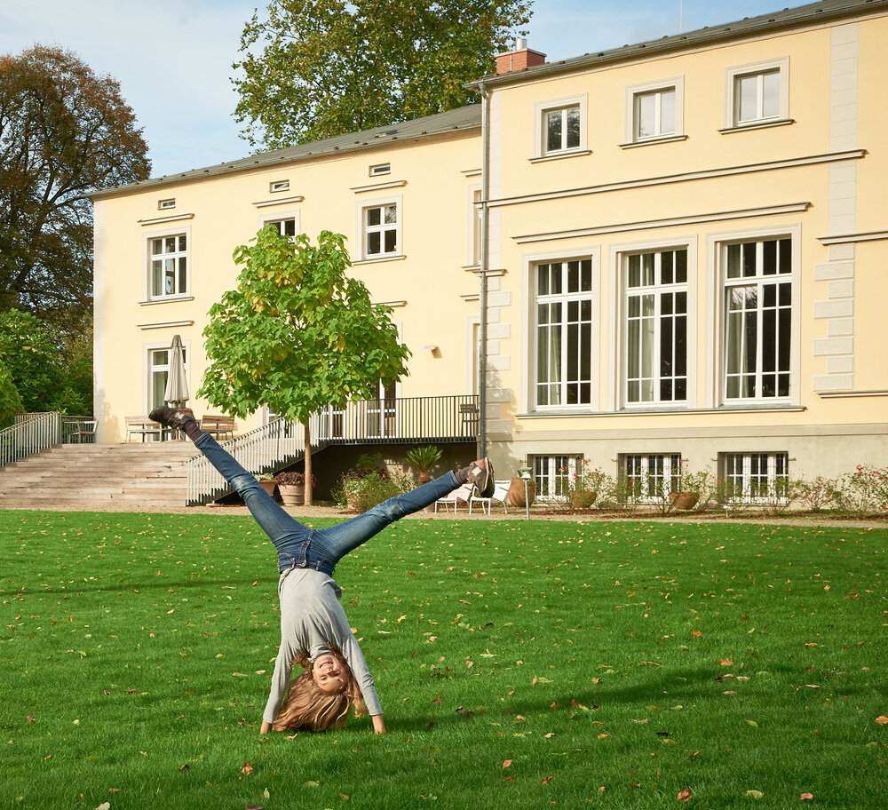 Ländliche Idylle in Vorpommern radschlagendes Kind vor Guthaus Landsdorf